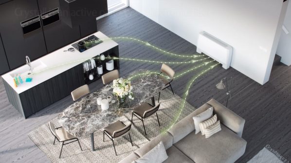 Una vista dall'alto di un'area open-space che include una cucina moderna con isola e un salotto con divano. Un'unità di filtraggio dell'aria è montata a parete sulla destra e delle linee luminose di colore verde chiaro indicano il flusso d'aria che si distribuisce dall'ambiente verso l'unità di filtraggio dell'aria. L'ambiente è arredato con mobili contemporanei e un tappeto geometrico.