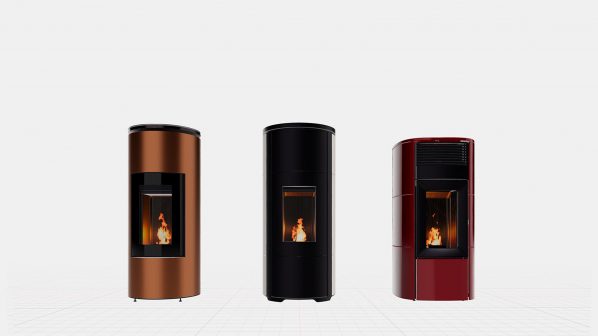 Tre stufe a pellet verticali, cilindriche o leggermente ovali, con fiamme visibili all'interno attraverso una finestra trasparente, sono esposte su uno sfondo bianco minimalista. Da sinistra a destra, i colori delle stufe sono: rame metallico lucido, nero opaco e rosso bordeaux lucido. Tutte e tre le stufe hanno un design moderno e pulito, con linee verticali eleganti e un'apertura quadrata o rettangolare per visualizzare il fuoco. I piedi delle stufe sono sottili e neri.