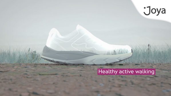Un'illustrazione digitale di una scarpa da ginnastica, con la tomaia trasparente che mostra la struttura interna e una suola robusta in grigio chiaro. La scarpa è posizionata su un terreno ghiaioso con uno sfondo sfocato di alberi o erba alta e nebbia. In basso a destra è presente un pannello rosa con la scritta "Healthy active walking", mentre in alto a destra compare il logo "Joya".